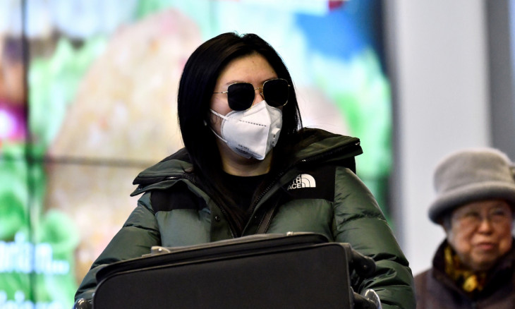 Travellers wearing masks arrive on a direct flight from China at Vancouver International Airport