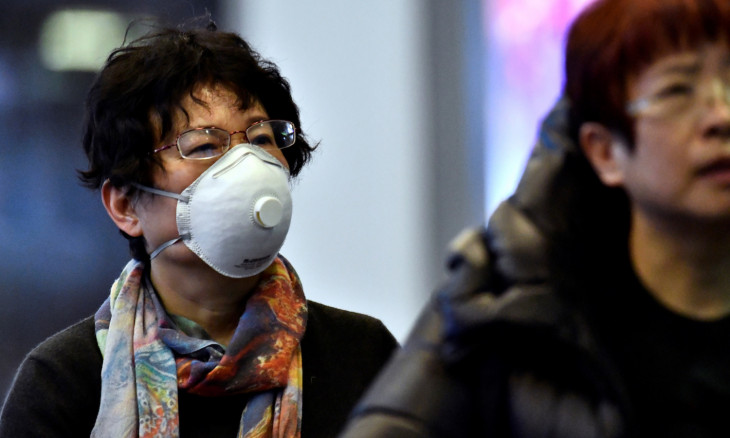 Travellers wearing masks arrive on a direct flight from China at Vancouver International Airport