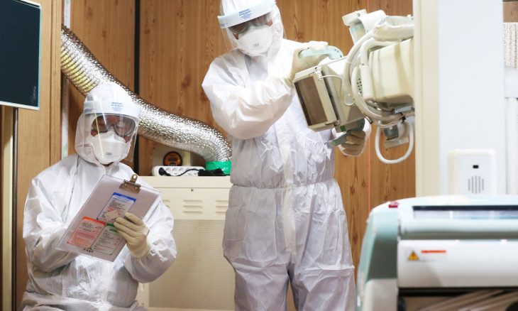 Medical workers check a makeshift examining room for possible patients infected by a new coronavirus at a hospital in Suwon