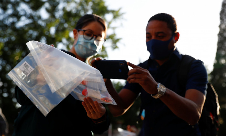 Journalists take pictures a test kit after being tested for the coronavirus disease (COVID-19) before attending a news conference