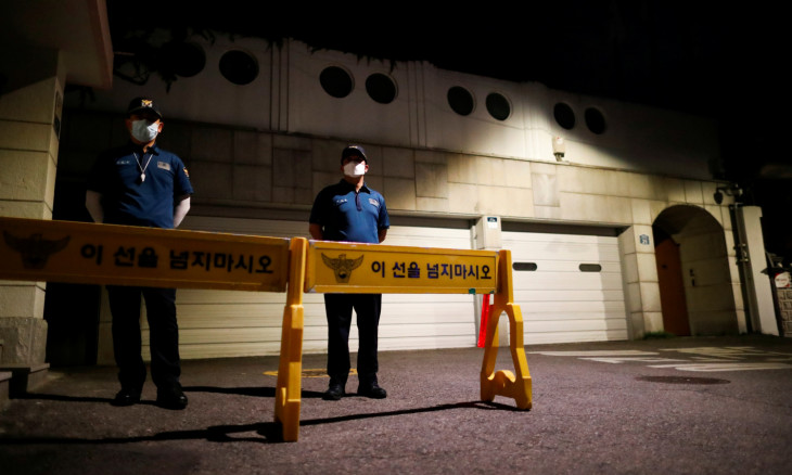 Police officers stand guard in front of the residence of Seoul Mayor Park Won-soon