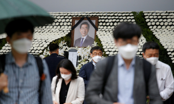 People react as they walk past a memorial altar for late Seoul Mayor Park Won-soon