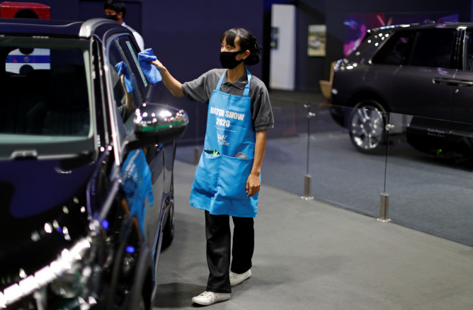 A staff member cleans a vehicle 