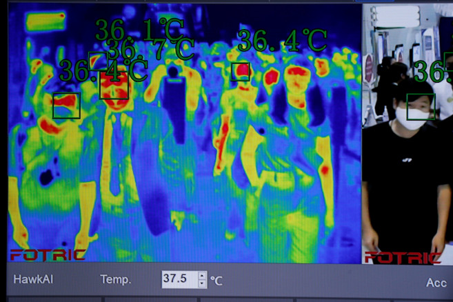 People are seen through the screen of a thermal scanner 