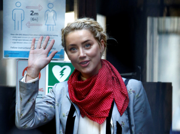 Actor Amber Heard waves as she arrives at the High Court