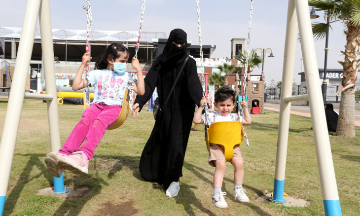 A Saudi woman is seen with her children at Abha Airport Park