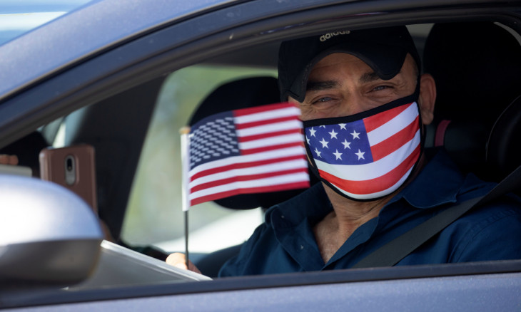 Palestinian Omar Abdalla waves a U.S. flag after being sworn-in as a newly naturalized United States citizens