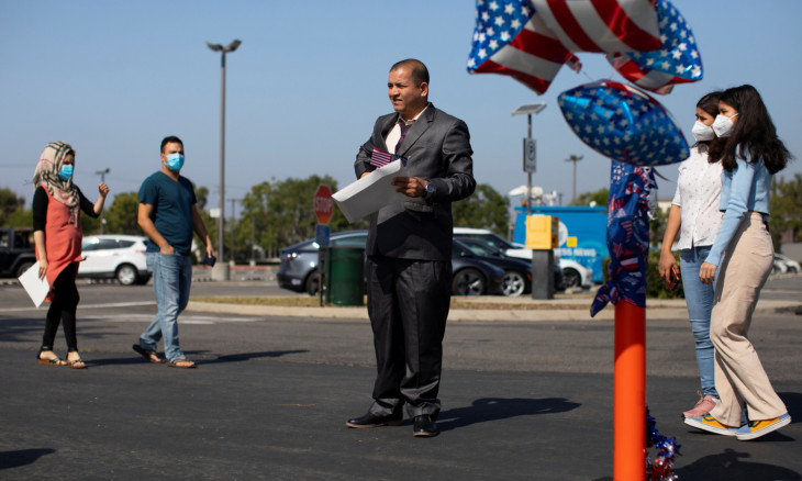 A newly sworn-in U.S. citizen waits to take a picture during a drive through immigration ceremony