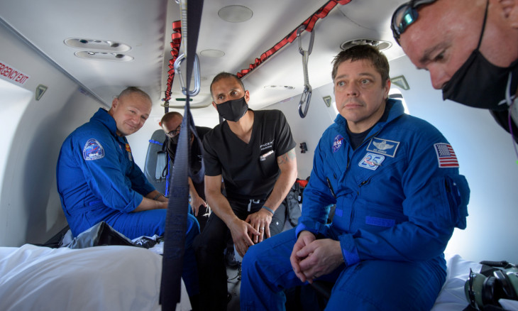 NASA astronauts Douglas Hurley (L) and Robert Behnken prepare to depart their helicopter