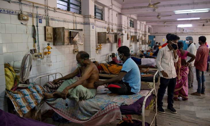Patients sit on hospital beds inside the emergency ward 
