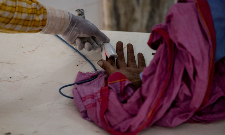 A health worker checks a patient's oxygen levels 