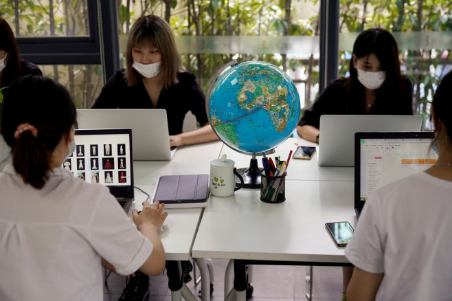 Employees from the export department of Suzhou Jusere Wedding & Evening Dress Co. Ltd work together on 