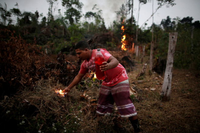 A man lights a fire to create a firebreak to stop the progress of a fire