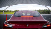 IIHS media relations associate Young demonstrates a front crash prevention test on a Tesla Model 3 at IIHS-HLDI Vehicle Research Center in Ruckersville, Virginia
