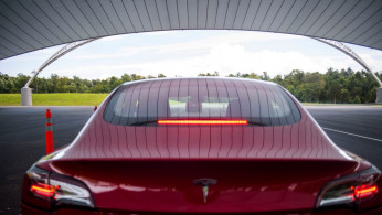 IIHS media relations associate Young demonstrates a front crash prevention test on a Tesla Model 3 at IIHS-HLDI Vehicle Research Center in Ruckersville, Virginia