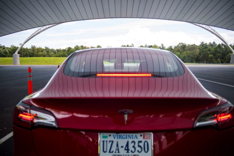 IIHS media relations associate Young demonstrates a front crash prevention test on a Tesla Model 3 at IIHS-HLDI Vehicle Research Center in Ruckersville, Virginia