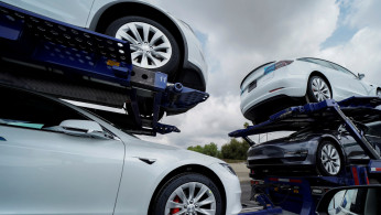 Tesla vehicles are shown on a delivery truck in Los Angeles