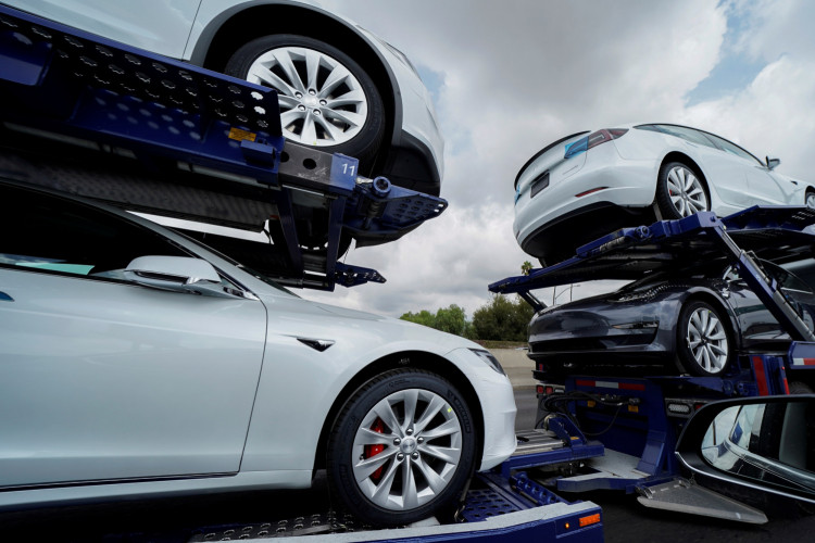 Tesla vehicles are shown on a delivery truck in Los Angeles