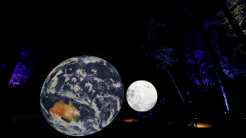 An earth and moon installation are reflected at the Enchanted Forest 2019 event Cosmos, an annual sound and light show, at Faskally Wood, Pitlochry, Scotland, Britain October 2, 2019. 