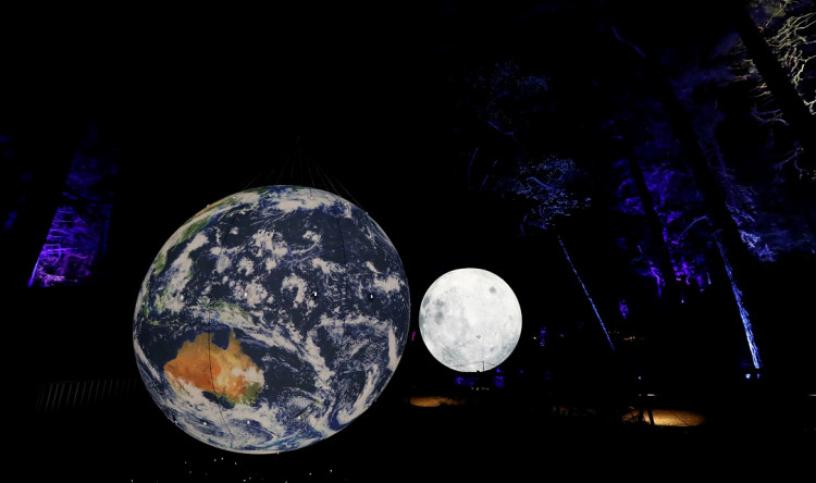 An earth and moon installation are reflected at the Enchanted Forest 2019 event Cosmos, an annual sound and light show, at Faskally Wood, Pitlochry, Scotland, Britain October 2, 2019. 