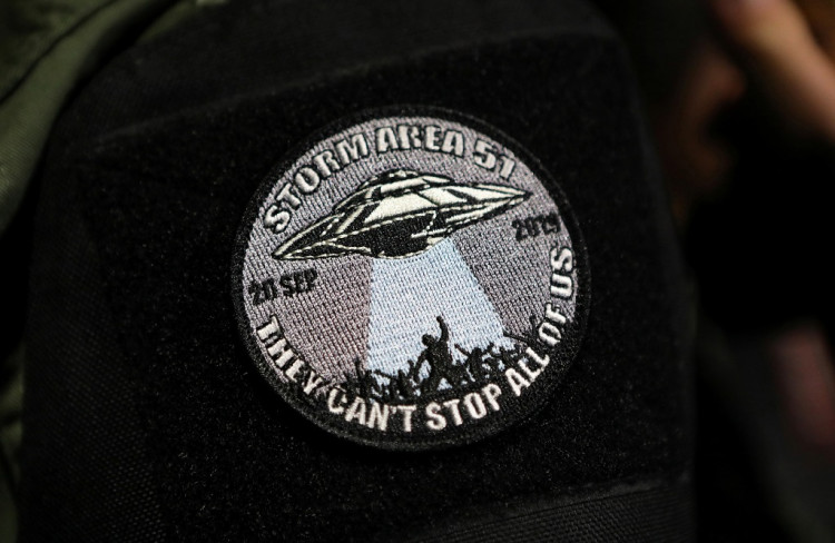 An attendee wears a patch outside a gate to Area 51 