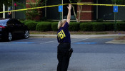 An FBI agent holds up crime scene tape as federal agents execute search warrants on multiple businesses in Lawrenceville, Georgia U.S. September 27, 2019. 