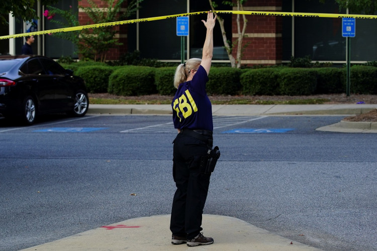 An FBI agent holds up crime scene tape as federal agents execute search warrants on multiple businesses in Lawrenceville, Georgia U.S. September 27, 2019. 