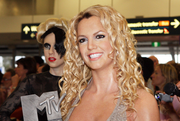 Britney Spears in a sparkling silver dress holding a music award.