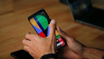 A woman takes a look on the new Google Pixel 4 smartphone displayed during a Google launch event in New York