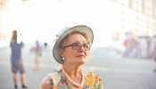 Depth of Field Photography of Woman in Pastel Color Sleeveless and White Sunhat.