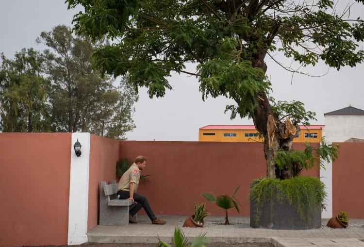 Britain's Prince Harry sits alone beneath the Diana Tree in Huambo