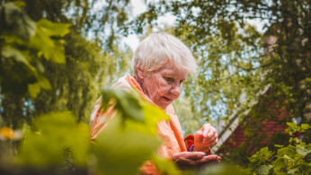 Shallow focus of a woman near plants.