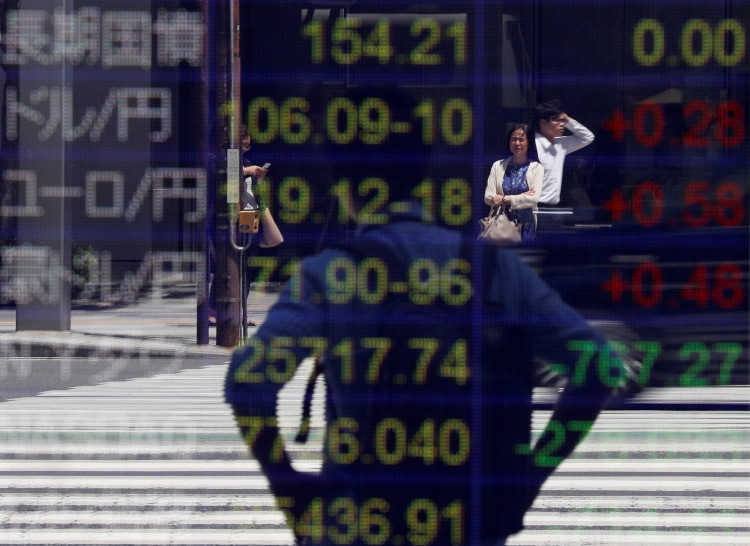 Japanese yen and the U.S. dollar, the yen against the euro, the yen against the Australian dollar, Dow Jones Industrial Average and other market indices outside a brokerage in Tokyo