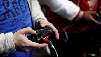 Visitors play games on PlayStation 4 (PS4) at the Paris Games Week, a trade fair for video games in Paris
