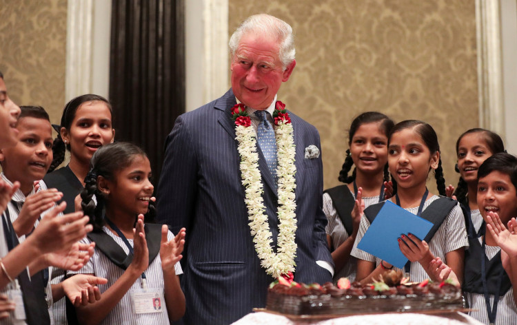 Britain's Prince Charles looks on as children from a school sing a birthday song for him in Mumbai