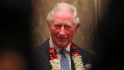 Britain's Prince Charles looks on as children from a school sing for him in Mumbai