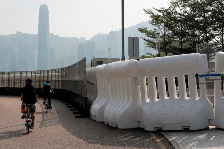 People ride bike passing barriers outside the West Kowloon Express Rail Link Station during a march at Hong Kong’s tourism district Tsim Sha Tsui
