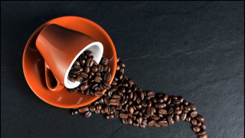 Coffee beans, ceramic mug, and saucer.