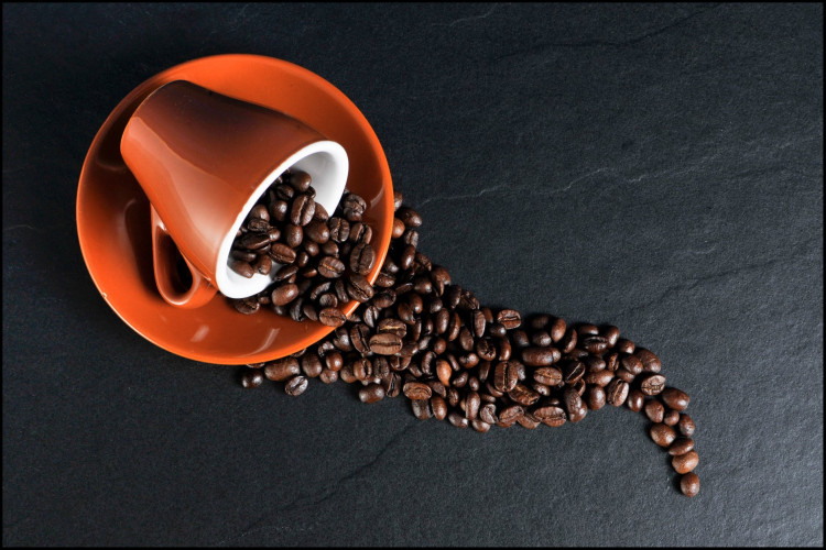Coffee beans, ceramic mug, and saucer.