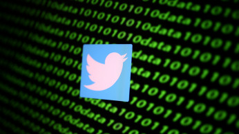 The Twitter logo and binary cyber codes are seen in this illustration
