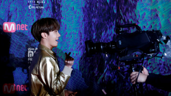 j-hope, a member of South Korean boy band BTS gestures to a camera on the red carpet during the annual MAMA Awards at Nagoya Dome in Nagoya