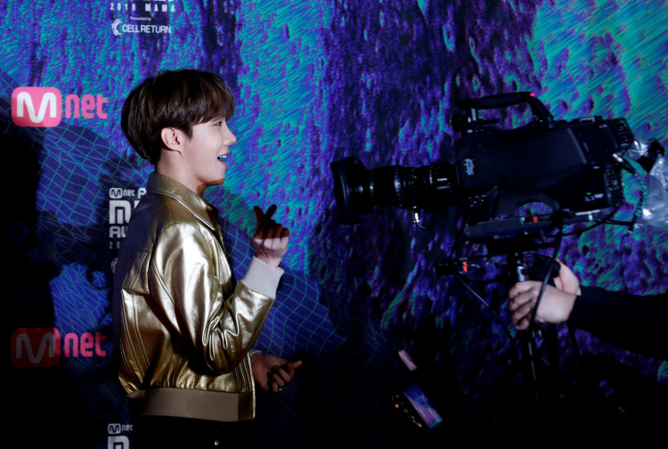 j-hope, a member of South Korean boy band BTS gestures to a camera on the red carpet during the annual MAMA Awards at Nagoya Dome in Nagoya