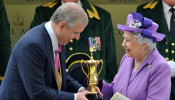 FILE PHOTO: Britain's Queen Elizabeth smiles as she is presented with The Gold Cup by her son Prince Andrew after her horse Estimate won the feature race during ladies day at the Royal Ascot horse racing festival at Ascot
