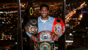 Anthony Joshua poses with the IBF, WBA, WBO & IBO World Heavyweight belts after winning his title fight against Andy Ruiz Jr
