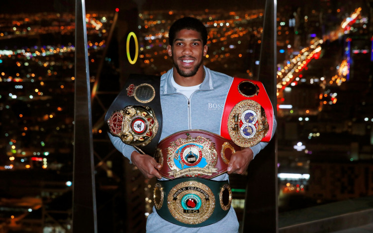 Anthony Joshua poses with the IBF, WBA, WBO & IBO World Heavyweight belts after winning his title fight against Andy Ruiz Jr