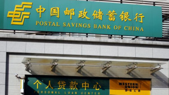 Man walks out of a Postal Savings Bank of China branch in Beijing