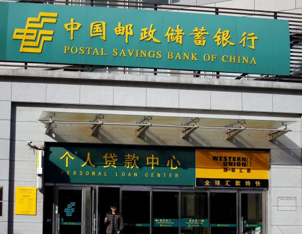Man walks out of a Postal Savings Bank of China branch in Beijing