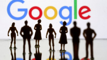 Small toy figures are seen in front of Google logo in this illustration picture