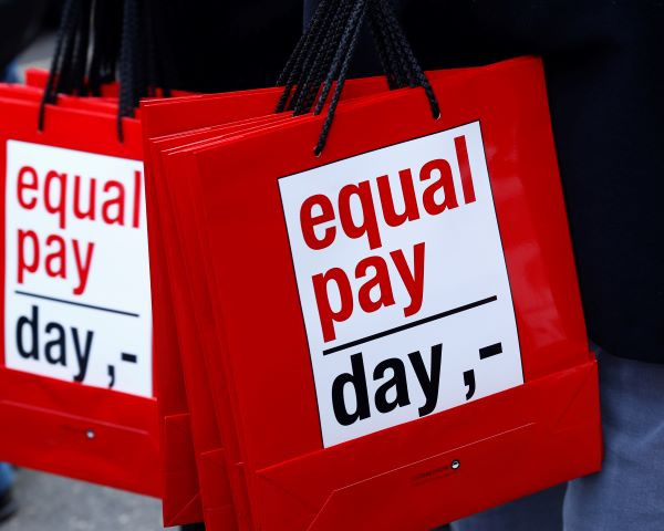 People carry bags reading 'equal pay day' during a protest a day before International Women's Day, in Bern March 7, 2015.