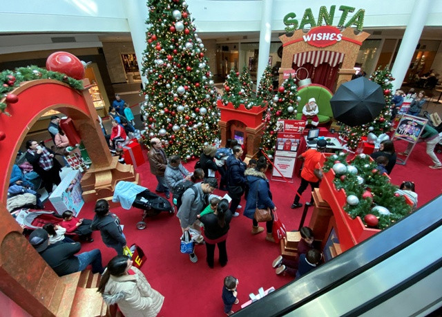 Families wait in line to meet Santa Claus at Fashion Centre at Pentagon City, decorated for the holidays, in Arlington, Virginia